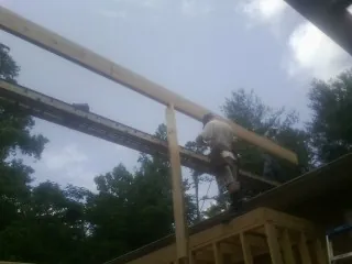 Carpenter setting a ridge beam over a new addition frame — Ice Dam Removal by Roofing Brothers in Cross Fork
