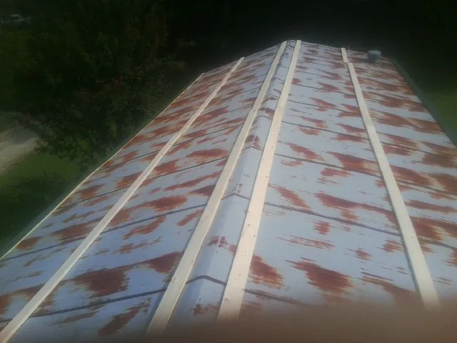 Rusted metal roof panels with new wood purlins before replacement — Storm Damage Roof Repair in Cross Fork by Roofing Brothers